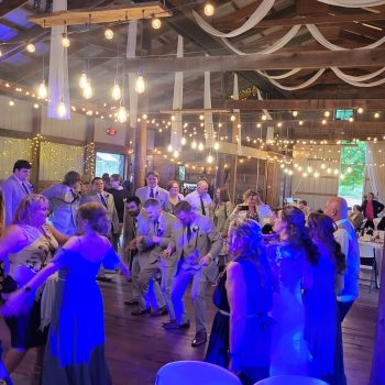 Wedding DJ Wedding reception guests dancing under string lights