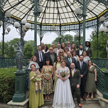 Wedding party gathered at an outdoor gazebo