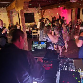 DJ console overlooking a crowded wedding reception dance floor